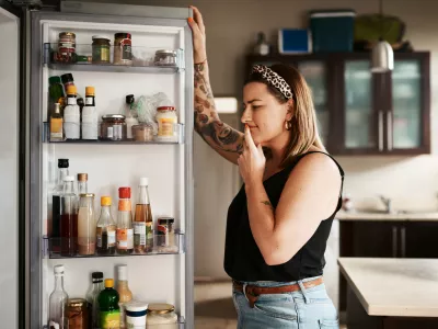 Shot of a young woman searching inside a refrigerator at home / Foto: Peopleimages Getty Images
