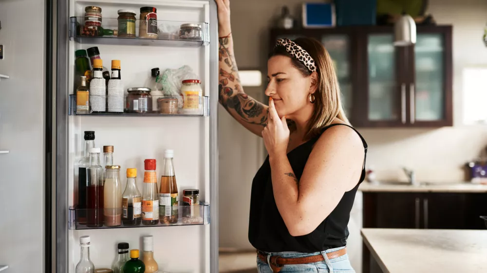 Shot of a young woman searching inside a refrigerator at home / Foto: Peopleimages Getty Images