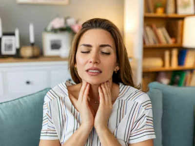Close up of young woman rubbing her inflamed tonsils, tonsilitis problem, cropped. Woman with thyroid gland problem, touching her neck, girl has a sore throat / Foto: Stefanamer