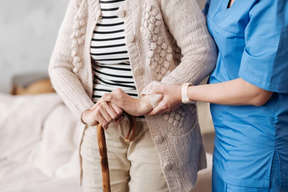 Sunset years. Admirable neat medical worker making sure elderly lady standing firm while she trying taking a little walk at home / Foto: Zinkevych Getty Images