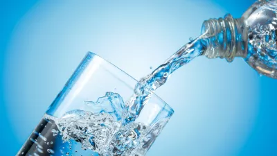 Clear drinking carbonated water pouring into a tall glass from a transparent plastic bottle. Blue backlight, copy space. / Foto: Igorr1