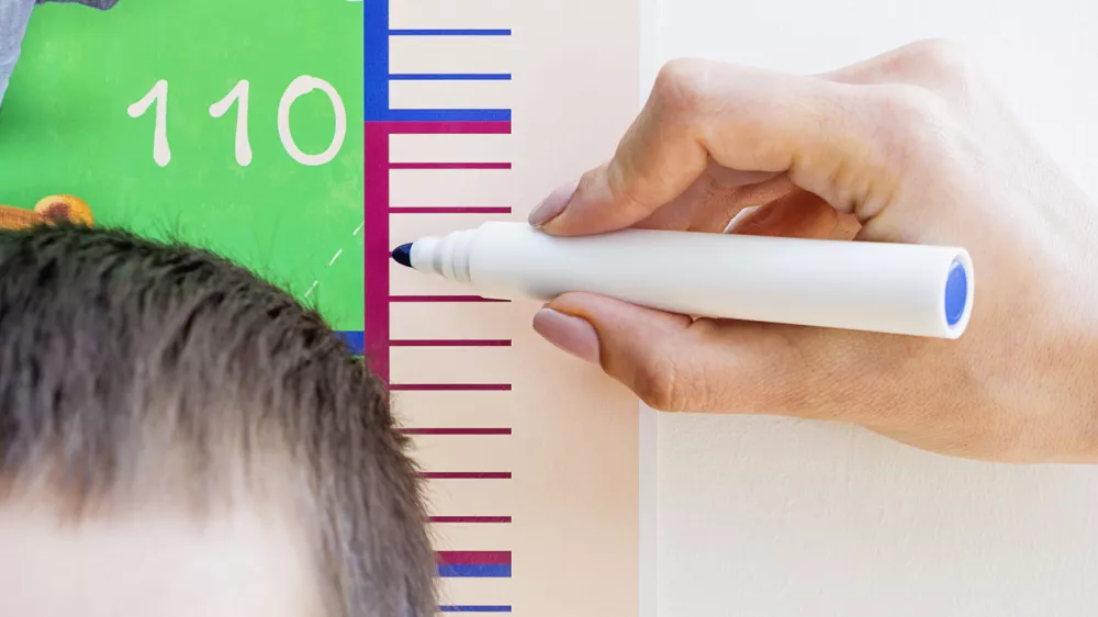 Mother measuring height of a 5 years old son. Selective focus, cropped image. / Foto: Evgen_prozhyrko Getty Images/istockphoto