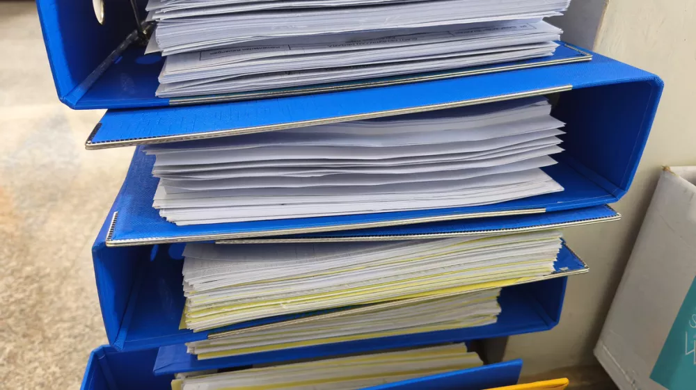 close-up view of colorful office binders stuffed with paperwork, illustrating heavy administrative workload, organization challenges, and office documentation processes / Foto: Mathlaul Anwar Getty Images