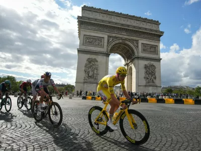 Slovenia's Tadej Pogacar, wearing the overall leader's yellow jersey, rides in front of the Arc de Triomphe during the last stage of the Tour de France cycling race with start and finish in Paris, Sunday, July 26, 2026. (AP Photo/Mosa'ab Elshamy)