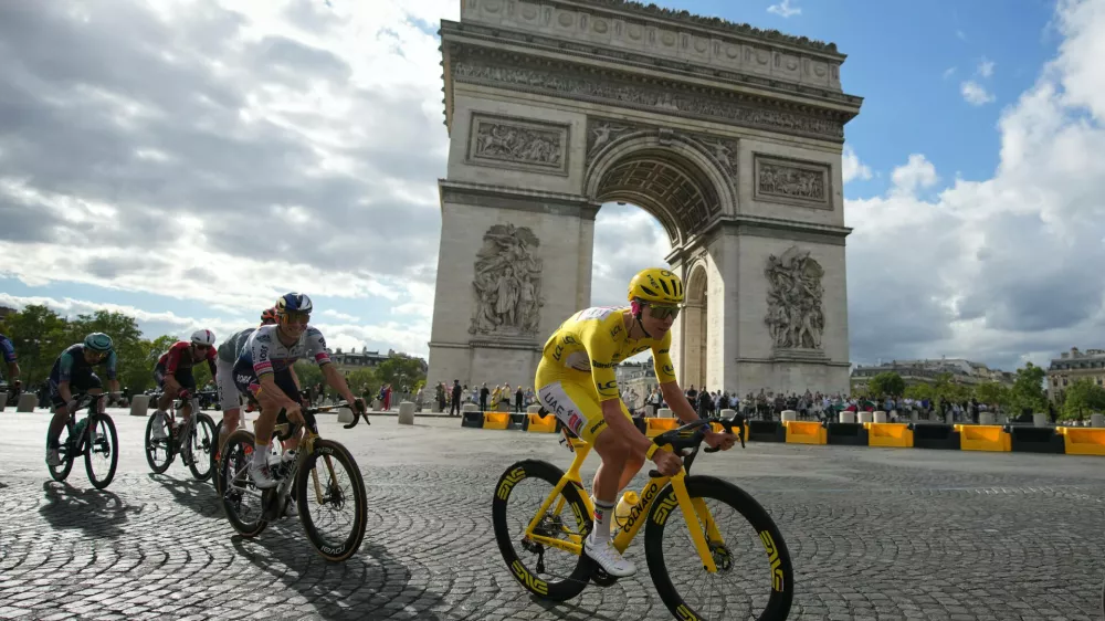 Slovenia's Tadej Pogacar, wearing the overall leader's yellow jersey, rides in front of the Arc de Triomphe during the last stage of the Tour de France cycling race with start and finish in Paris, Sunday, July 26, 2026. (AP Photo/Mosa'ab Elshamy)