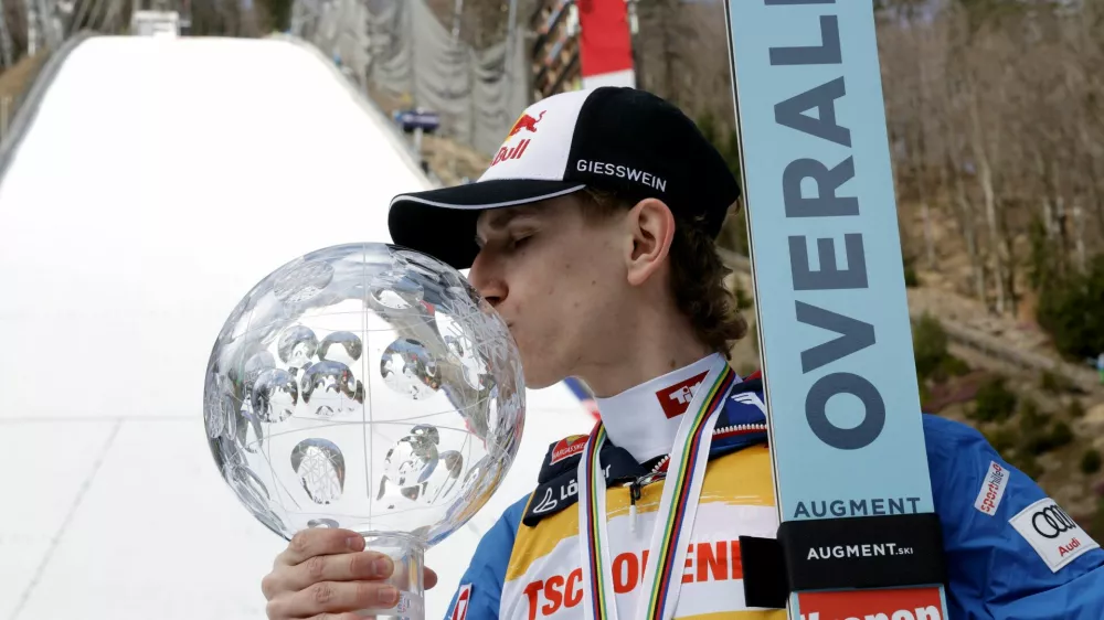Ski Jumping - FIS Ski Jumping World Cup - Planica, Slovenia - March 30, 2025 Austria's Daniel Tschofenig kisses a trophy after finishing as the overall winner of the FIS Ski Jumping World Cup REUTERS/Borut Zivulovic