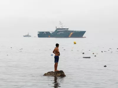 A youth from Morocco stands on a rock in the water, looking towards a Spanish Guardia Civil vessel, amid mass crossings of migrants on foot and by sea from Morocco into Spanish territory in Ceuta, Spain, July 31, 2026. REUTERS/Jon Nazca   TPX IMAGES OF THE DAY