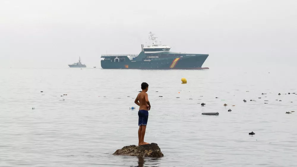 A youth from Morocco stands on a rock in the water, looking towards a Spanish Guardia Civil vessel, amid mass crossings of migrants on foot and by sea from Morocco into Spanish territory in Ceuta, Spain, July 31, 2026. REUTERS/Jon Nazca   TPX IMAGES OF THE DAY