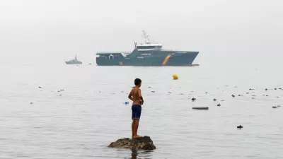 A youth from Morocco stands on a rock in the water, looking towards a Spanish Guardia Civil vessel, amid mass crossings of migrants on foot and by sea from Morocco into Spanish territory in Ceuta, Spain, July 31, 2026. REUTERS/Jon Nazca   TPX IMAGES OF THE DAY
