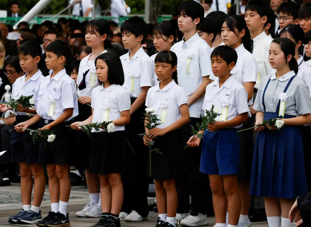 Children hold flowers during a ceremony commemorating the 81st anniversary of the bombing of the city, at Nagasaki's Peace Park in Nagasaki, southwestern Japan, August 9, 2026. REUTERS/Manami Yamada