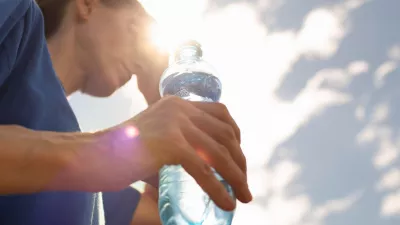 Woman drinking water in extreme summer heat wave.