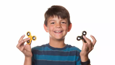 Boy on White Background Playing With Two Fidget Spinners