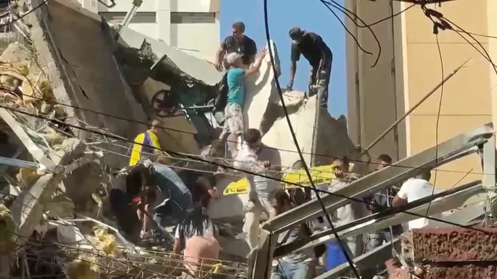 Rescue workers and residents stand atop a collapsed building in the aftermath of an earthquake in Cali, Colombia, August 10, 2026 in this screengrab taken from a video. REUTERS/Reuters TV