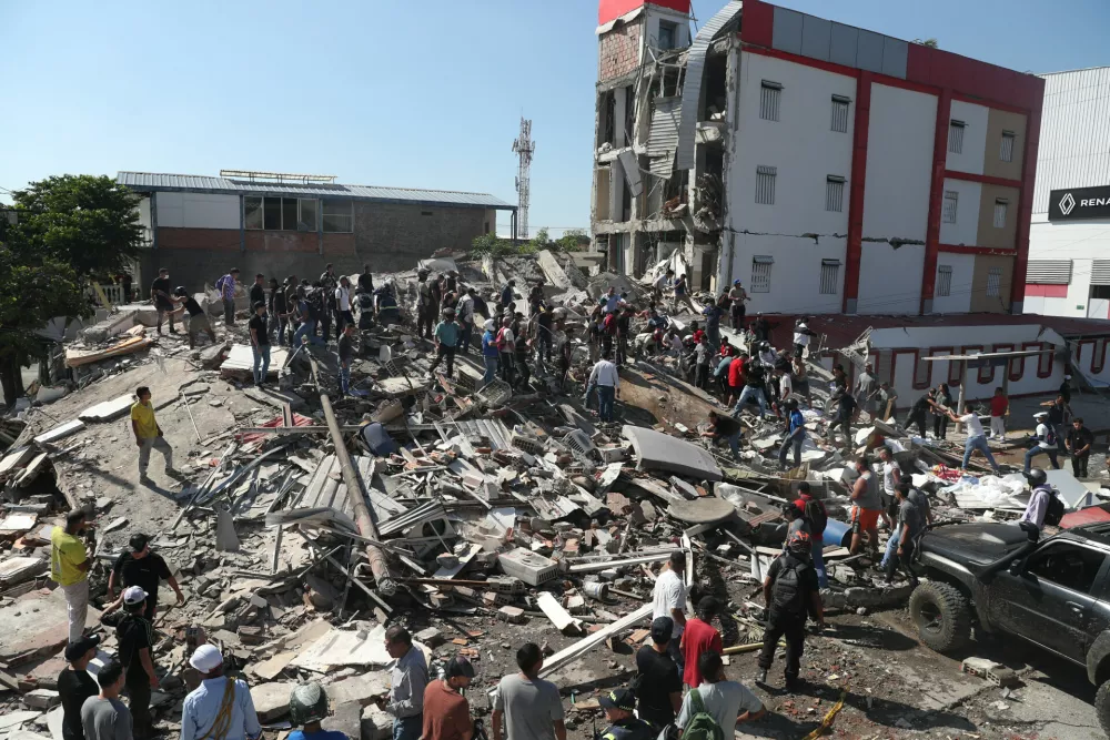 Residents and rescue workers search through the rubble of a collapsed building after an earthquake struck Cali, Colombia, Monday, Aug. 10, 2026. (AP Photo/Santiago Saldarriaga)