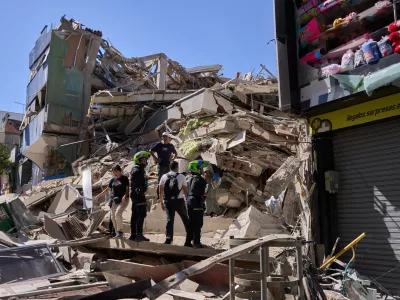 Police look at a building damaged after an earthquake struck Pereira, Colombia, Monday, Aug. 10, 2026. (AP Photo/Vladimir Encima)