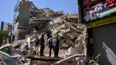 Police look at a building damaged after an earthquake struck Pereira, Colombia, Monday, Aug. 10, 2026. (AP Photo/Vladimir Encima)