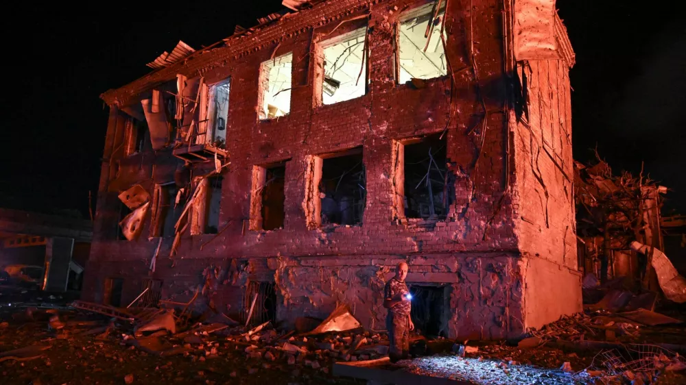 A resident stands next to a building damaged by an overnight Russian missile strike, amid Russia's attack on Ukraine, in Zaporizhzhia, Ukraine August 11, 2026. REUTERS/Stringer