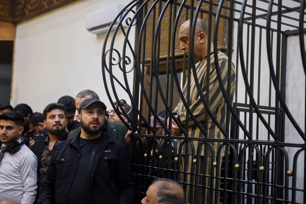 FILE -Atef Najib, former head of the Political Security Branch in the Daraa area during Bashar Assad's rule, sits in the defendants' cage during a trial session at the Palace of Justice in Damascus, Syria, April 26, 2026. (AP Photo/Ghaith Alsayed), File)