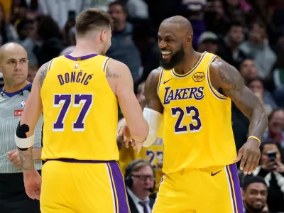 Los Angeles Lakers forward/guard Luka Dončić (77) celebrates a three point basket with forward LeBron James (23) against the New Orleans Pelicans during the second half of an NBA basketball game in New Orleans, Tuesday, Jan. 6, 2026. (AP Photo/Matthew Hinton)