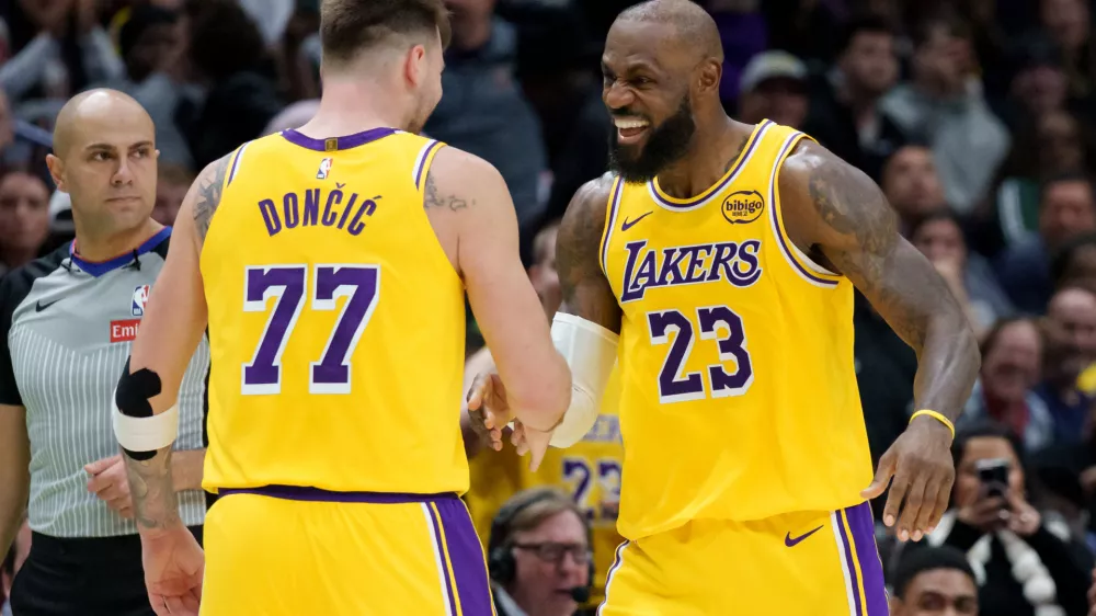 Los Angeles Lakers forward/guard Luka Dončić (77) celebrates a three point basket with forward LeBron James (23) against the New Orleans Pelicans during the second half of an NBA basketball game in New Orleans, Tuesday, Jan. 6, 2026. (AP Photo/Matthew Hinton)