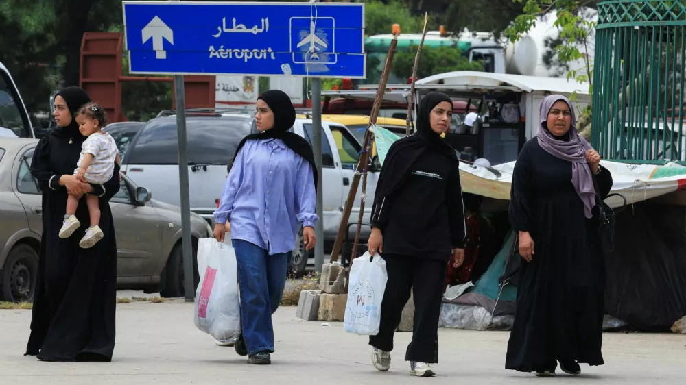 Women walk on a street as people make their way while fleeing the southern suburbs of Beirut, after Israeli Prime Minister Benjamin Netanyahu ordered the military to attack targets in the suburbs, Lebanon, June 1, 2026. REUTERS/Mohamed Azakir