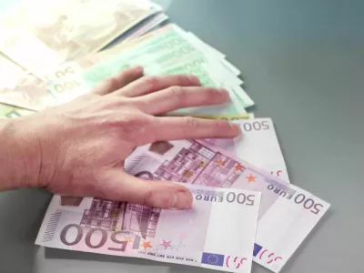 Close up of a hand grabbing money, concept of greed, indoor shot with particular focus