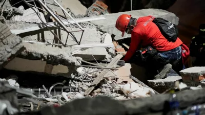A rescuer searches for survivors under the rubble at the Torres de Limonar building in the aftermath of an earthquake, in Cali, Colombia, August 11, 2026. REUTERS/Sergio Acero