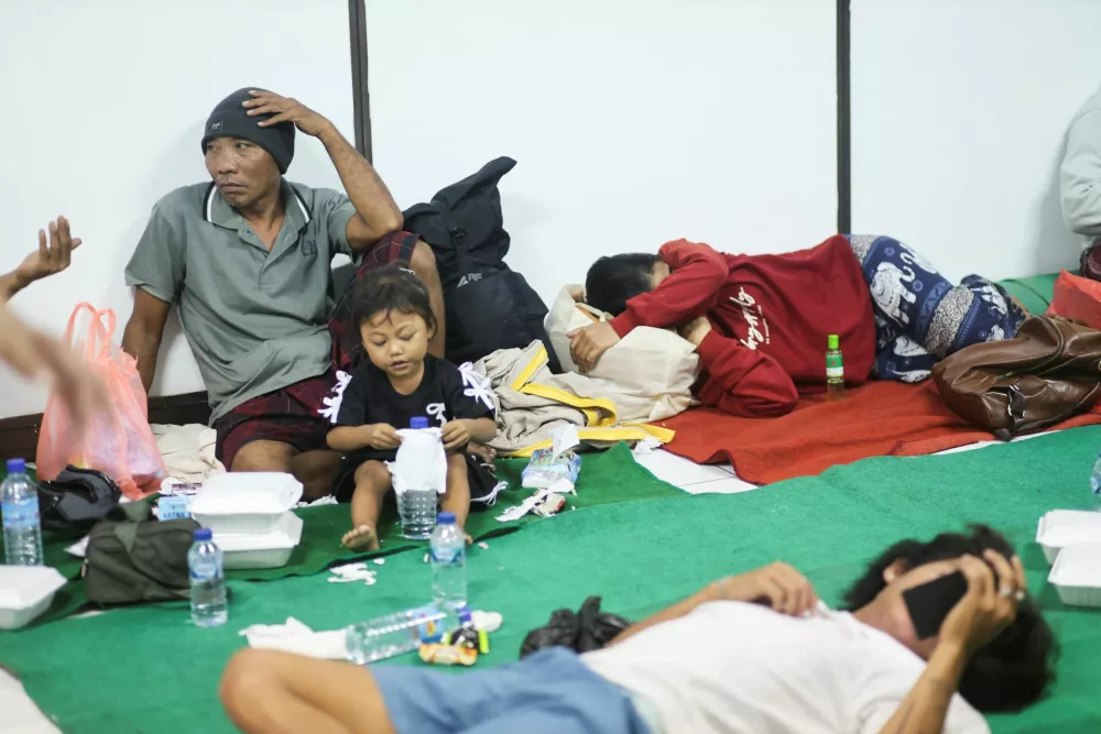 Passengers evacuated from the KM Putri Yasmin, a ferry with around 130 people on board, travelling from the Indonesian tourist island of Bali that caught fire in waters off Lombok, rest at the Padangbai port in Karangasem, Bali, Indonesia, August 12, 2026. REUTERS/Johannes Christo
