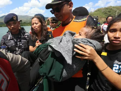 Passengers on board the KM Putri Yasmin, a ferry with around 130 people travelling from Bali that caught fire in waters off Lombok, react after being evacuated at Lembar port in Lombok, West Nusa Tenggara province, Indonesia, August 12, 2026. REUTERS/Stringer