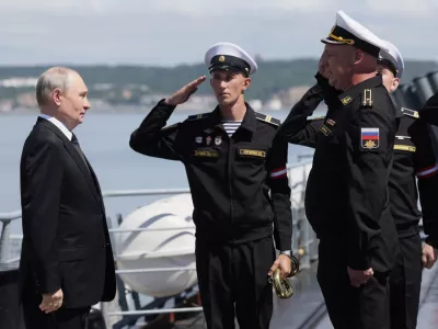 Russian President Vladimir Putin, left, visits the Varyag missile cruiser of the Pacific Fleet to watch a military exercise near Yuzhno-Sakhalinsk, on Sakhalin Island, Russia, Wednesday, Aug. 12, 2026. (Gavriil Grigorov, Sputnik, Kremlin Pool Photo via AP)