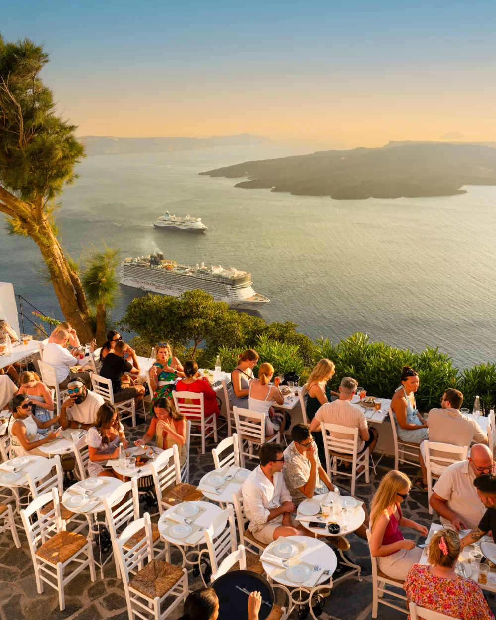 Fira, Santorini, Greece - August 24, 2025: Tourists Enjoying Dinner with a Stunning Aegean Sea View in Fira