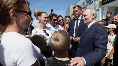 Russian President Vladimir Putin, right, interacts with local residents in Kurilsk on the Iturup Island, the largest of the Kuril Islands of Russia's far-east, Thursday, Aug. 13, 2026. (Gavriil Grigorov, Sputnik, Kremlin Pool Photo via AP)