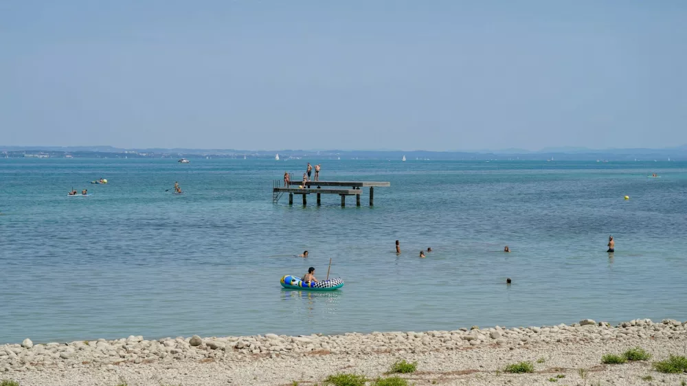 Bodensee: Badeg&auml;ste und Wassersportler genie&szlig;en einen sonnigen Sommertag im Bodensee. Menschen schwimmen im See, fahren mit Schlauchboot und Stand-up-Paddle weitere Personen stehen auf einem Badesteg. Im Hintergrund Segelboote und das gegen&uuml;berliegende Ufer. Sommer, Hitze, Freizeit, Baden, Schwimmen, Wassersport, Tourismus, Ferien, Erholung, See, Strand, Badesteg, SUP, Panorama, Totale, Symbolbild. *** Lake Constance: Swimmers and water sports enthusiasts enjoy a sunny summer day on Lake Constance. People are swimming in the lake, riding in inflatable boats, and stand-up paddleboarding others are standing on a swimming dock. In the background are sailboats and the opposite shore. Summer, heat, leisure, swimming, water sports, touri Copyright: xJOERANxSTEINSIEKx,Image: 1122385421, License: Rights-managed, Restrictions: imago is entitled to issue a simple usage license at the time of provision. Personality and trademark rights as well as copyright laws regarding art-works shown must be observed. Commercial use at your own risk., Model Release: no 