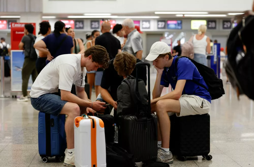 Passengers sit on their luggage in the check-in hall, a day after an ash cloud from Sicily's Mount Etna volcano drifted over Malta, forcing the cancellation of some flights to and from the Mediterranean island at the height of the tourism season, at Malta International Airport in Gudja, Malta, August 12, 2026. REUTERS/Darrin Zammit Lupi