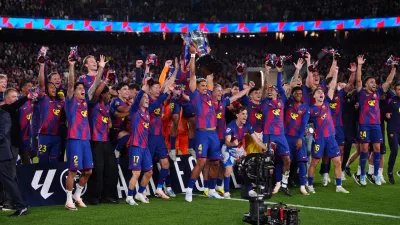 Barcelona's Ronald Araujo lifts the trophy after defeating Real Madrid 2-0 to win the Spanish La Liga soccer championship with three rounds to spare, in Barcelona, Spain, Sunday, May 10, 2026. (AP Photo/Joan Mateu Parra)