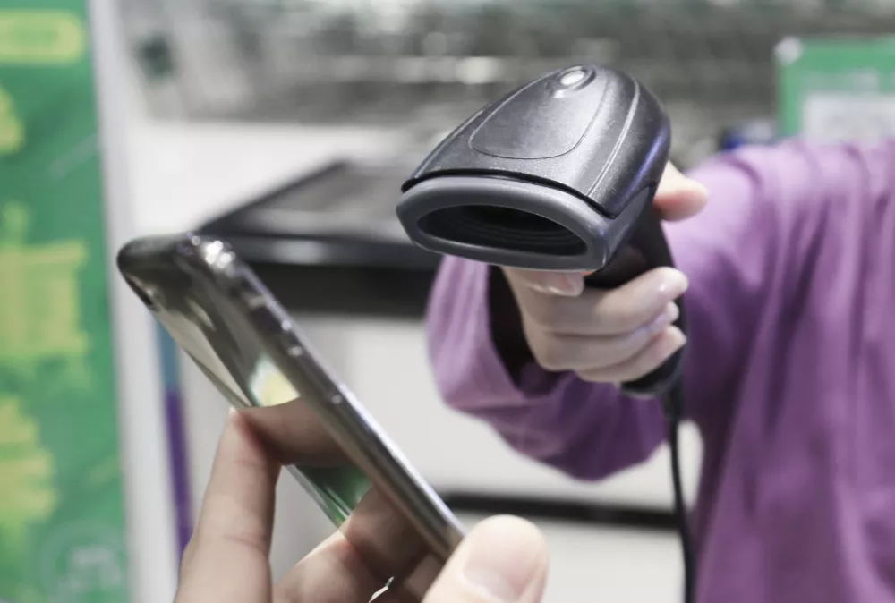 WeChat payment and supermarket sweep code gun. Closeup of a customer using her smartphone and nfs technology to pay.Who Pays by Contactless Mobile Phone to Credit Card System.
