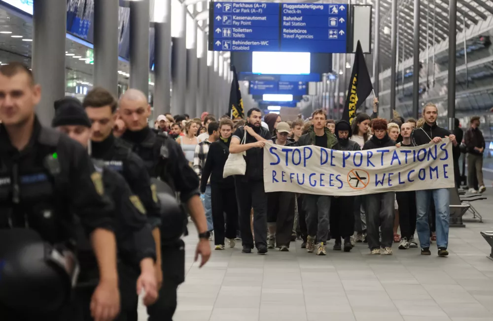 Participants in a left-wing demonstration are walking through the terminal at Leipzig-Halle Airport carrying a banner. They are protesting an alleged deportation flight to Afghanistan.