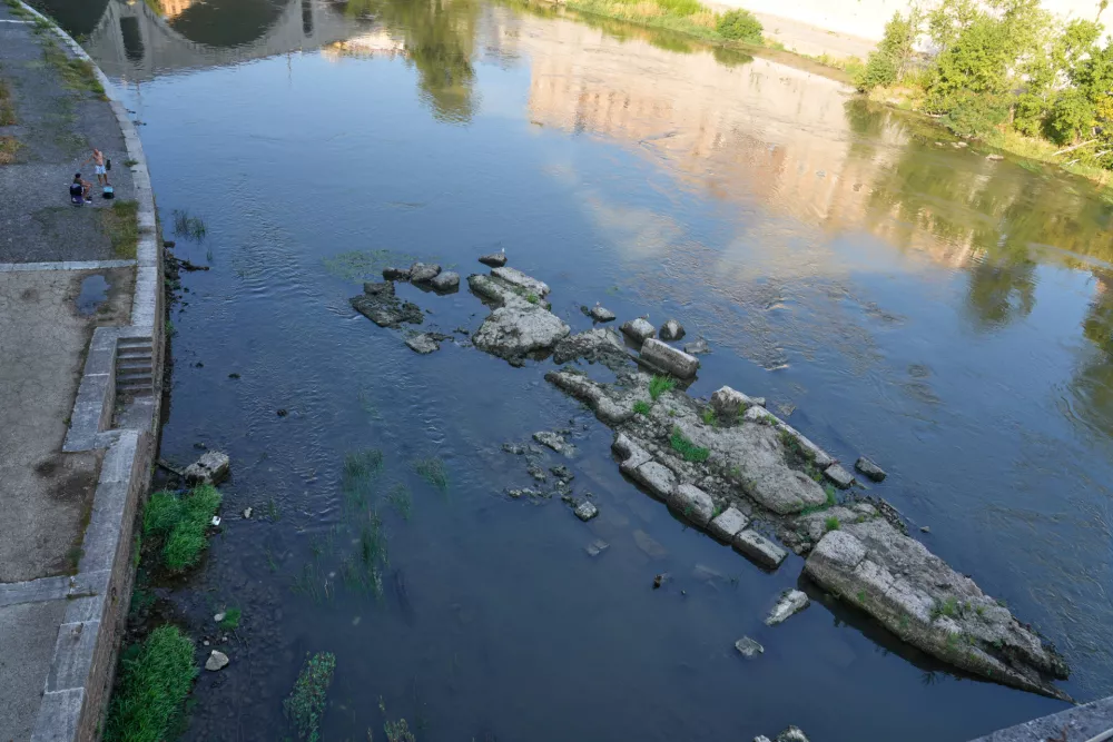 The ruins of the ancient Roman Neronian bridge, emerge from the riverbed of the Tiber river due to drought, in Rome, Thursday, Aug. 13, 2026. (AP Photo/Gregorio Borgia)