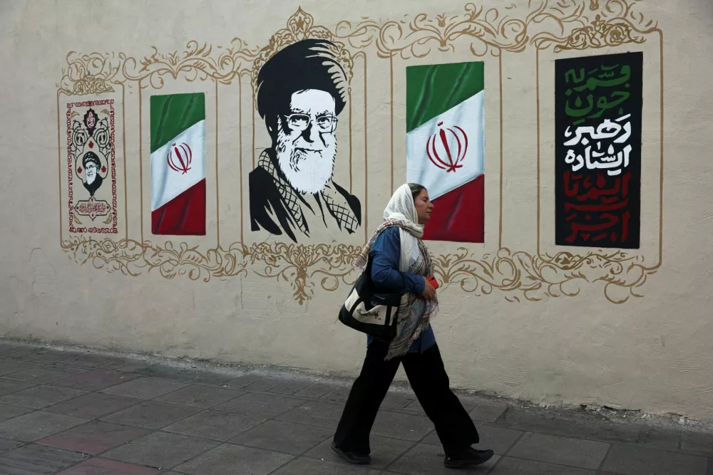 A woman walks by a mural depicting Iran's late Supreme Leader Ayatollah Ali Khamenei, on a street in Tehran, Iran, August 13, 2026. Majid Asgaripour/WANA (West Asia News Agency) via REUTERS ATTENTION EDITORS - THIS PICTURE WAS PROVIDED BY A THIRD PARTY. ISRAEL OUT. NO COMMERCIAL OR EDITORIAL SALES IN ISRAEL. NO ACCESS FOR ISRAELI MEDIA. NO USE BBC PERSIAN. NO USE VOA PERSIAN. NO USE MANOTO. NO USE IRAN INTERNATIONAL. NO USE RADIO FARDA. DIGITAL: NO USE BBC PERSIAN. NO USE VOA PERSIAN. NO USE MANOTO. NO USE IRAN INTERNATIONAL. NO USE RADIO FARDA.