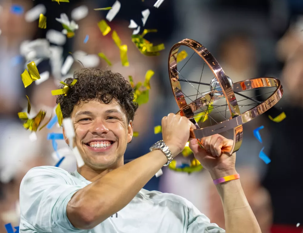 Ben Shelton of the United States hoists the trophy following his win over compatriot Brandon Nakashima during final tennis action at the National Bank Open in Montreal on Thursday, Aug. 13, 2026. (Christinne Muschi/The Canadian Press via AP)