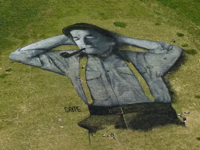 A painting, created by French artist Saype and said to be the world's largest biodegradable painting, is seen on the Chaux-de-Mont ski slope above the Alp resort of Leysin on August 4, 2016. The 100 meter long and 100 meter large painting is made with flour, linseed oil, water and biodegradable natural pigments.,Image: 296151457, License: Rights-managed, Restrictions: RESTRICTED TO EDITORIAL USE - MANDATORY MENTION OF THE ARTIST UPON PUBLICATION - TO ILLUSTRATE THE EVENT AS SPECIFIED IN THE CAPTION, Model Release: no 