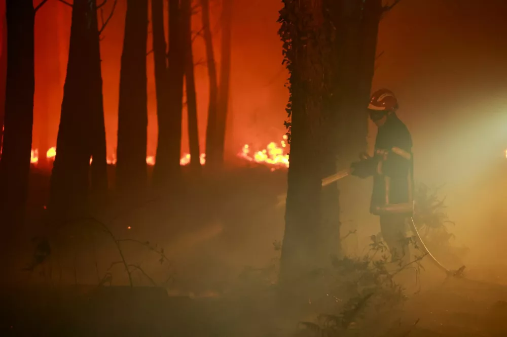A firefighter works following a wildfire burning in Luglon, France, August 14, 2026. REUTERS/Stephanie Lecocq