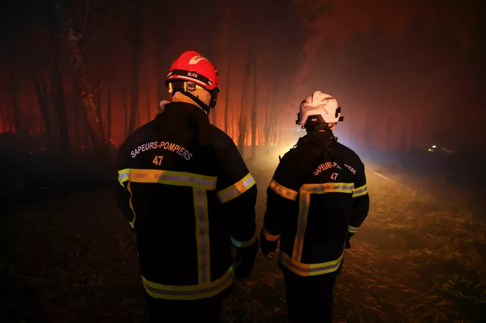 Firefighters operate following a wildfire burning in Luglon, France, August 14, 2026. REUTERS/Stephanie Lecocq