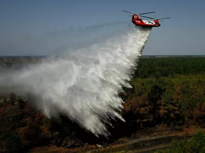 An Australian New South Wales Rural Fire Service (RFS) CH-47D Chinook water-bombing helicopter drops water over a pine massif during an exercise on the eve of its operational launch, near Captieux, south-western France, August 12, 2026.   PHILIPPE LOPEZ/Pool via REUTERS