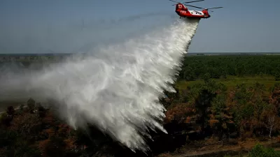 An Australian New South Wales Rural Fire Service (RFS) CH-47D Chinook water-bombing helicopter drops water over a pine massif during an exercise on the eve of its operational launch, near Captieux, south-western France, August 12, 2026.   PHILIPPE LOPEZ/Pool via REUTERS