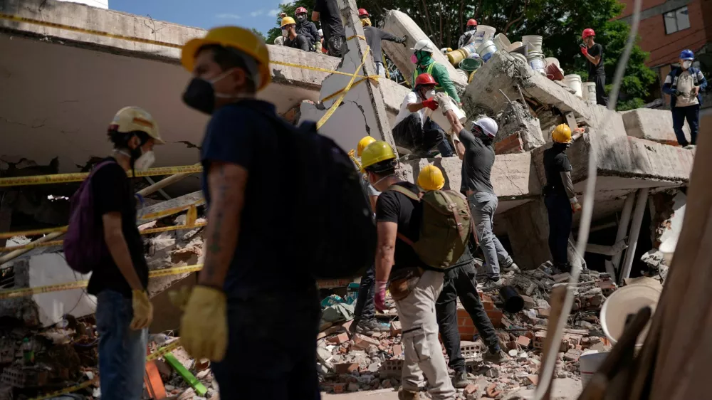 People clean up debris, as search and rescue operations are under way at the site of a destroyed Cantabria building, following the earthquake in Cali, Colombia, August 13, 2026. REUTERS/Sergio Acero