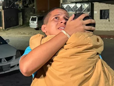 Leomar Guerra hugs a child after his release from El Rodeo prison under Venezuela's government "Peace and Democratic Coexistence" program, in Guatire, Venezuela, August 14, 2026. Picture taken with a mobile phone. REUTERS/Luis Colmenares