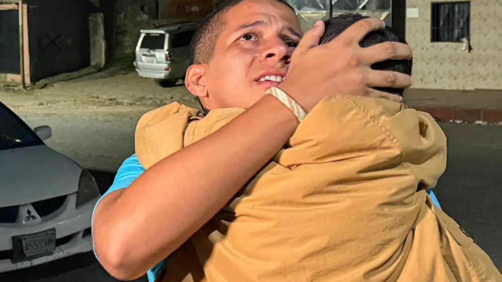 Leomar Guerra hugs a child after his release from El Rodeo prison under Venezuela's government "Peace and Democratic Coexistence" program, in Guatire, Venezuela, August 14, 2026. Picture taken with a mobile phone. REUTERS/Luis Colmenares