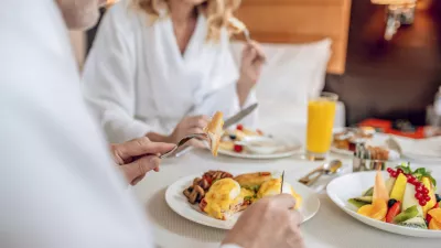 Breakfast time. A couple in white robes having breakfast and looking pleased
