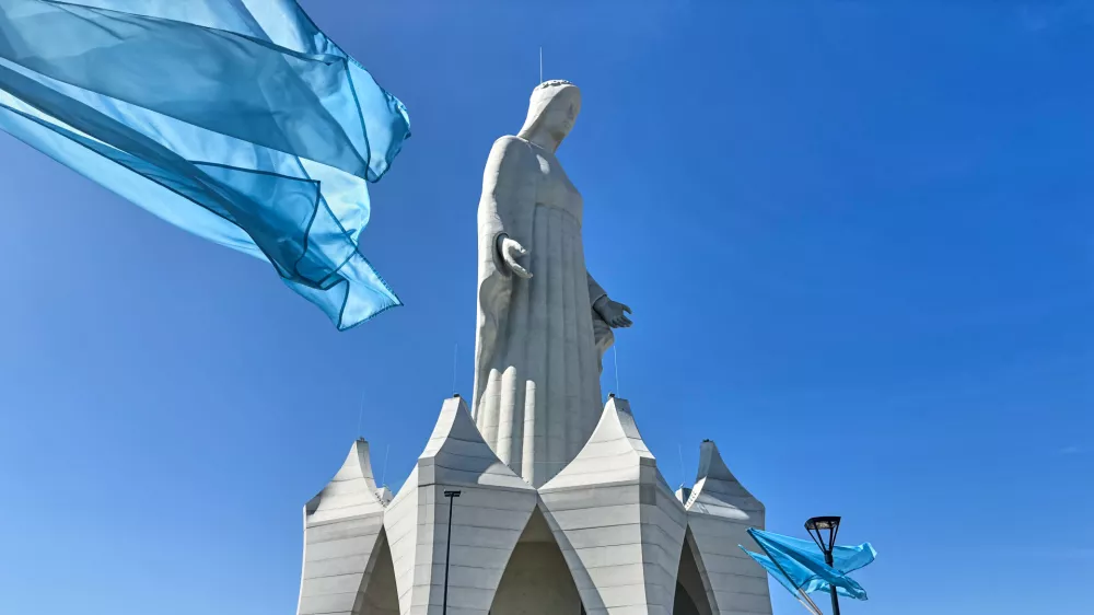 Flags wave in the wind in front of an enormous statue of the Virgin Mary that is believed to be Europe's tallest during the inauguration in the village Konotopie, Poland, Saturday, Aug. 15, 2026. (AP Photo/Claudia Ciobanu) / Foto: Claudia Ciobanu